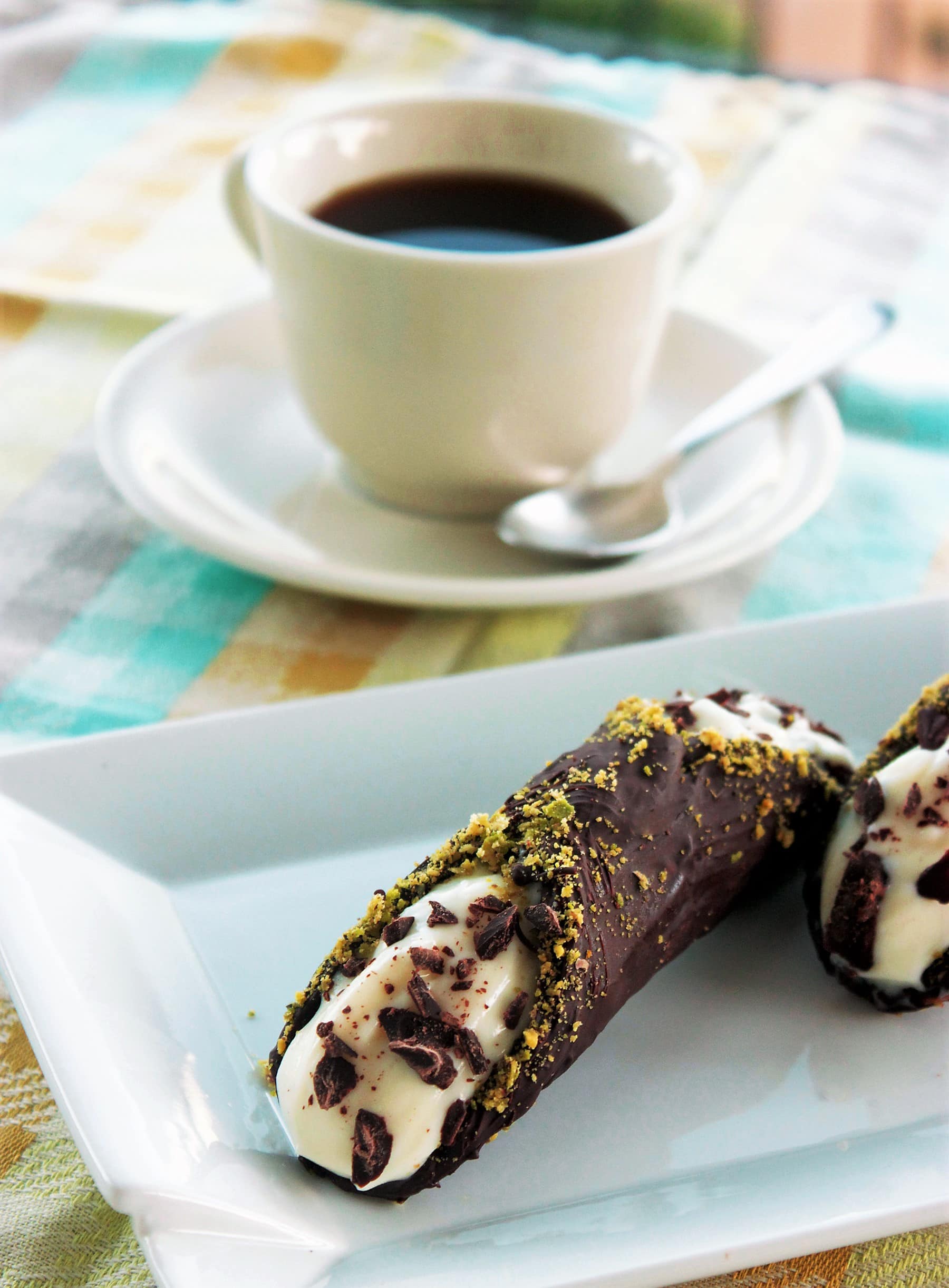A sweet fried crispy dough dipped in dark chocolate and filled with the most fresh citrusy ricotta cheese, bits of dark chocolate and pistachios. The most famous Sicilian dessert in the world! Recipe from The Petite Cook