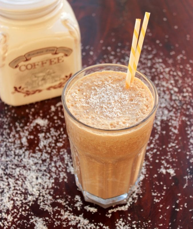 vegan coffee milkshake served in a tall glass and decorated with shredded dried coconut