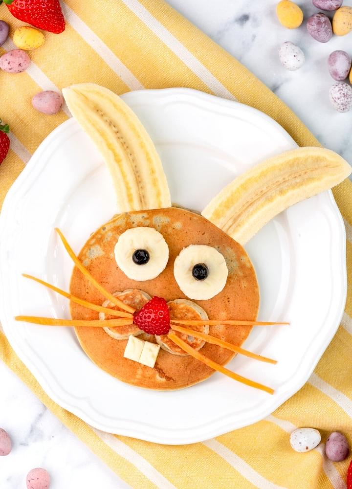 Easter bunny pancake decorated with bananas, strawberry, blueberries and carrot.