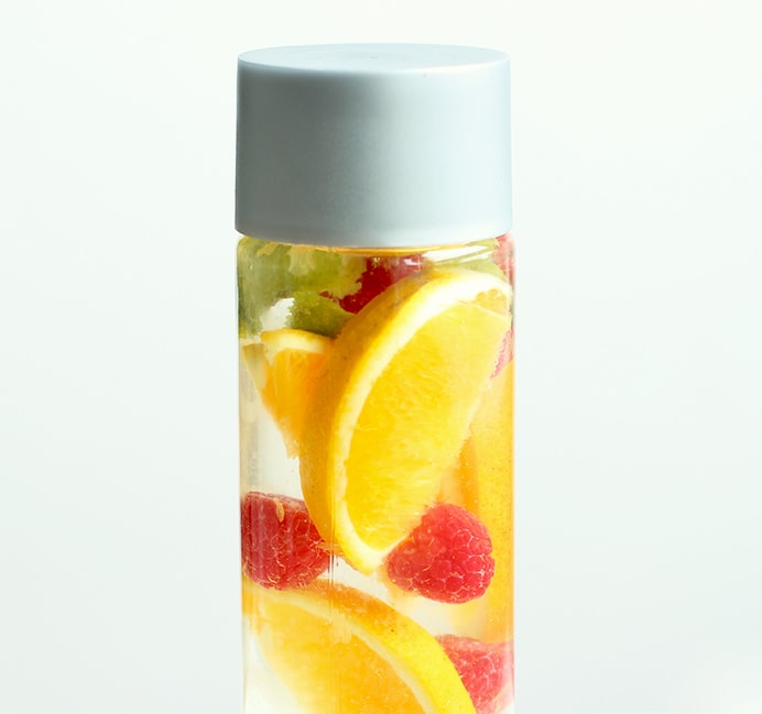 orange and raspberry fruit water in a glass bottle