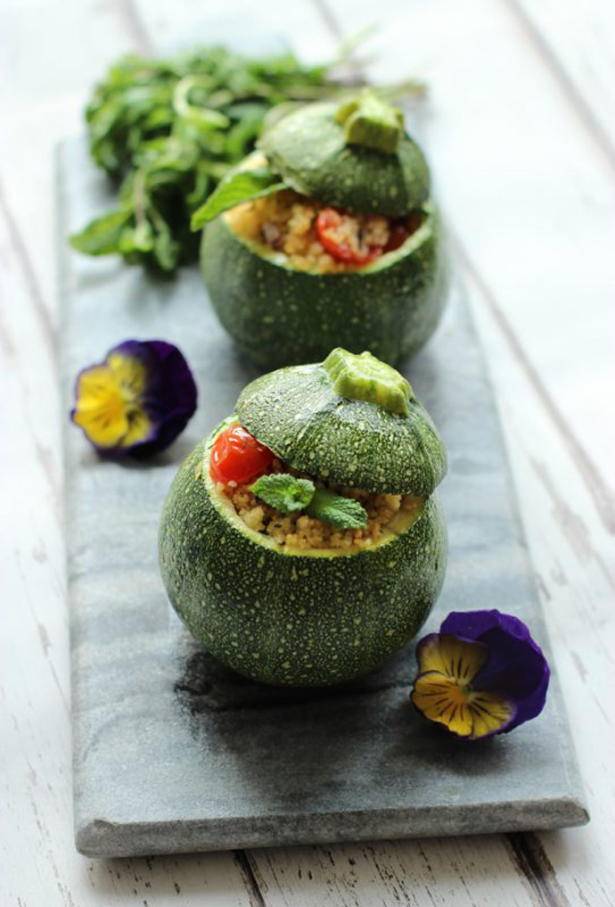 two couscous salad stuffed round zucchini.