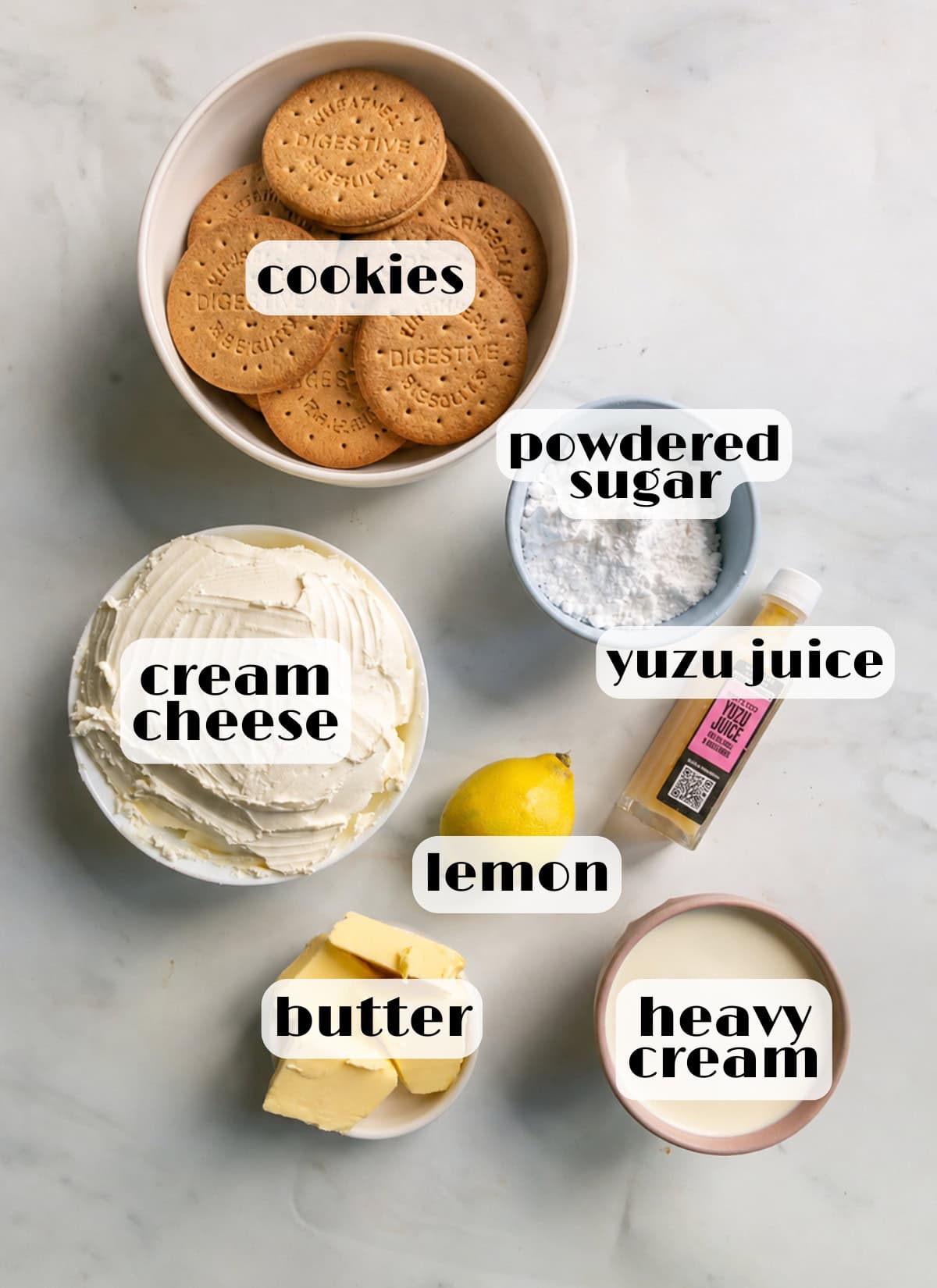 Ingredients for yuzu cheesecake: digestive cookies, butter, powdered sugar, yuzu juice, heavy cream, cream cheese, lemon zest.