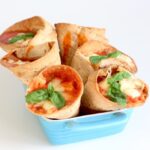 taco pizza cones stuffed with marinara sauce, mozzarella and basil leaves.