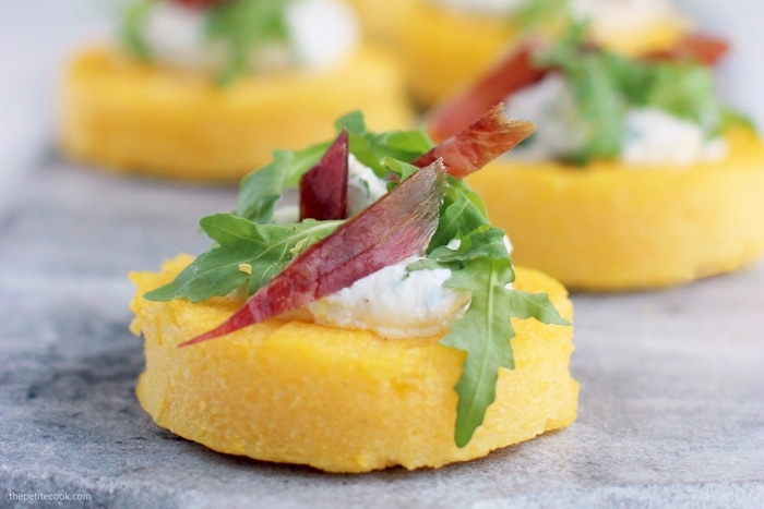 polenta crostini topped with ricotta, jamon, rocket leaves