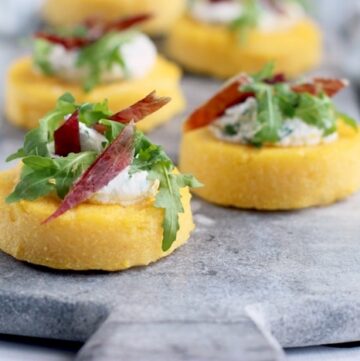 polenta crostini topped with jamon, ricotta and rocket leaves