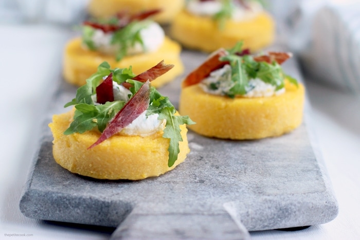 polenta crostini topped with jamon, ricotta and rocket leaves