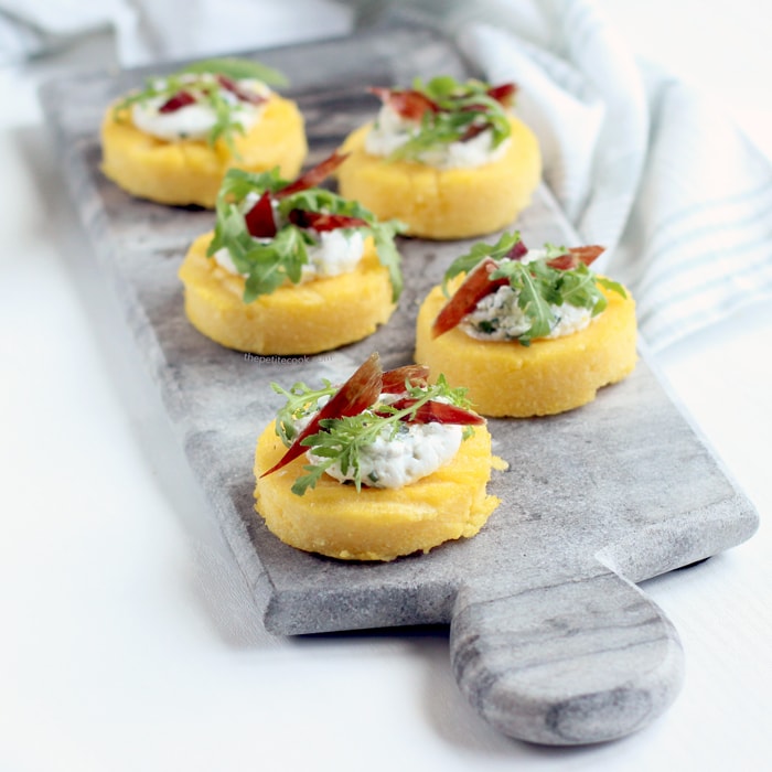 polenta crostini topped with jamon, ricotta and rocket leaves