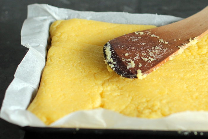 recipe step 3: level the polenta so that it forms an even rectangular base, let it cool then cut into rounds using a cookie cutter