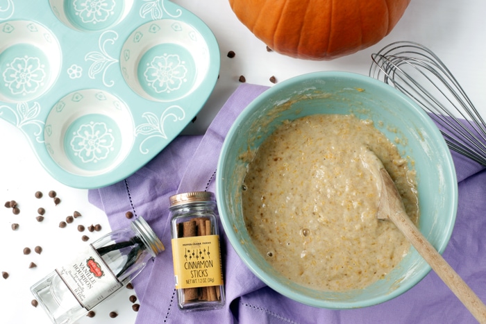 recipe step 3: bowl with pumpkin muffins batter mixed and ready to be transfered to the muffin tin next to the bowl.