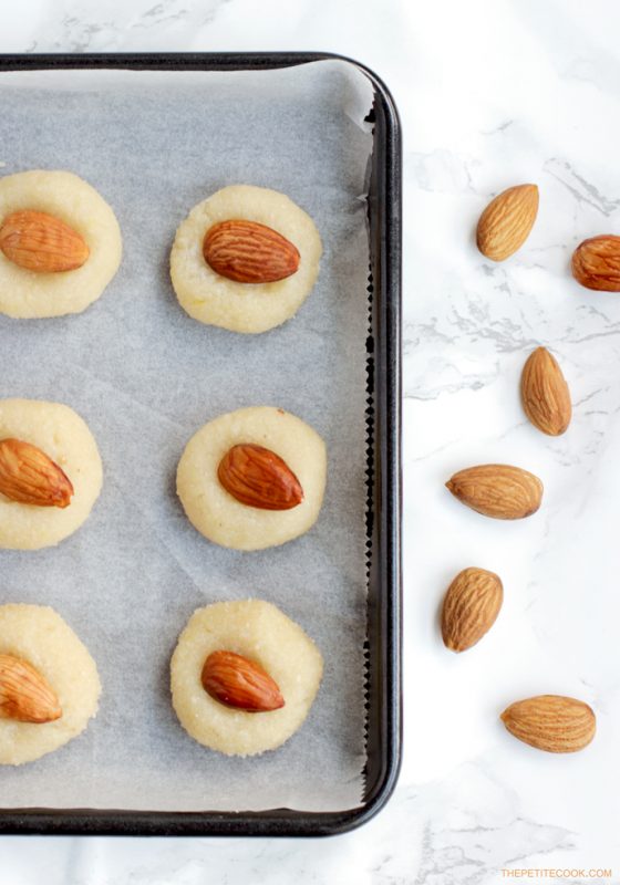 recipe step 5: almond cookies arranged on a baking tray covered with parchment paper, ready to go in the oven