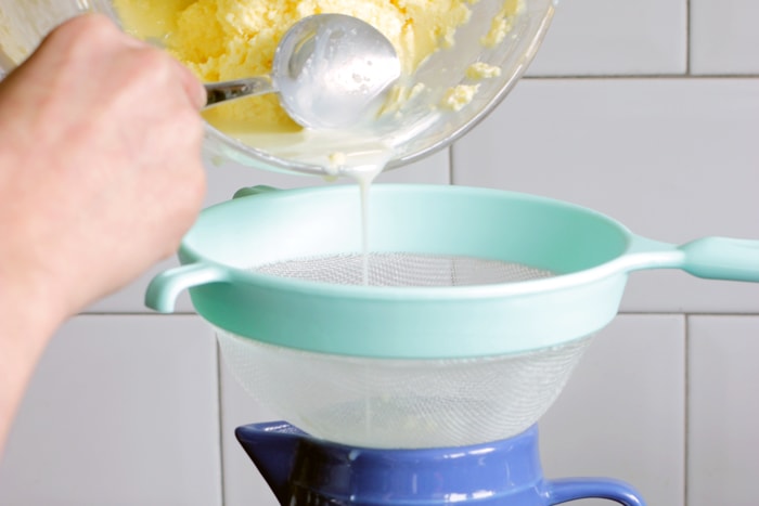 homemade butter recipe step 4, butter goes through a strainer to drain the buttermilk