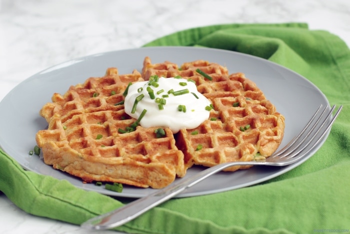 large sweet potato waffle topped with sour cream and chive, served on a plate