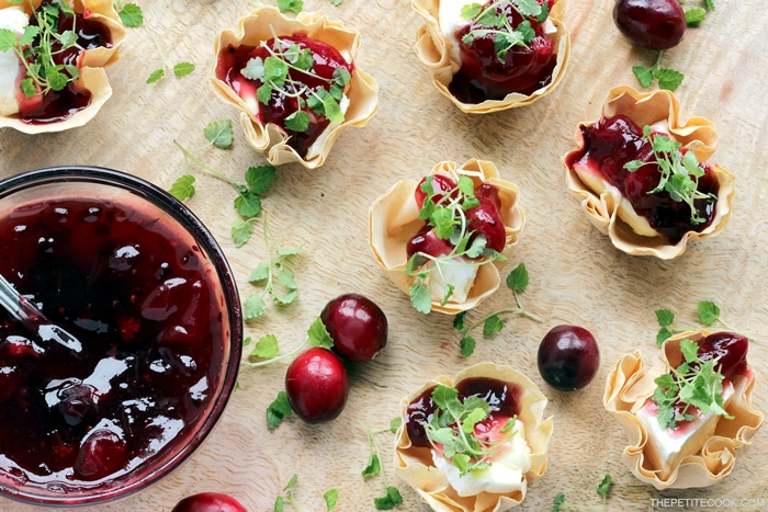 brie and cranberry cups on a wood board served with homemade cranberry sauce