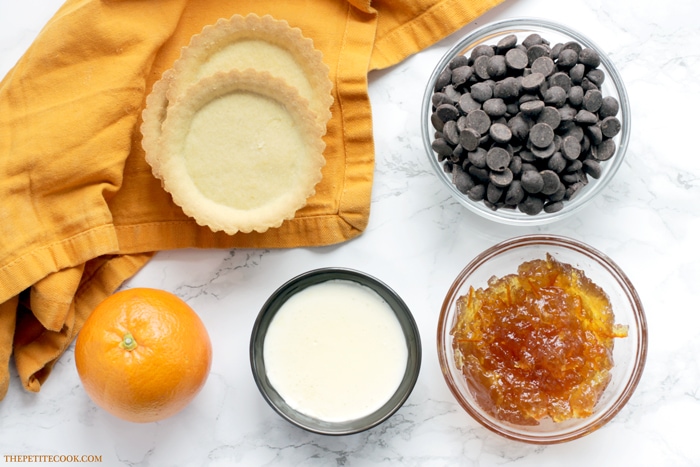 This delicious Mini Jaffa Tarts give a new twist to a classic British treat. The indulgent chocolate and orange combo makes a great dinner party dessert. Recipe from www.thepetitecook.com