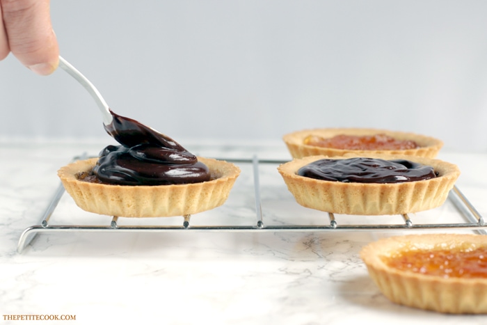 This delicious Mini Jaffa Tarts give a new twist to a classic British treat. The indulgent chocolate and orange combo makes a great dinner party dessert. Recipe from www.thepetitecook.com