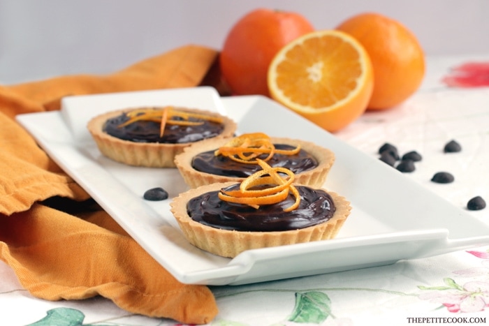 This delicious Mini Jaffa Tarts give a new twist to a classic British treat. The indulgent chocolate and orange combo makes a great dinner party dessert. Recipe from www.thepetitecook.com