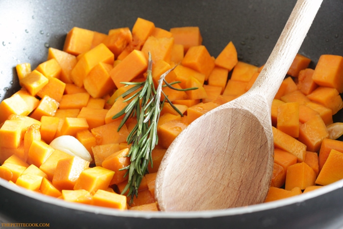 recipe step 1: pumpkin cubes, rosemary sprigs and garlic, stir-fried in a pan with extra-virgin olive oil.