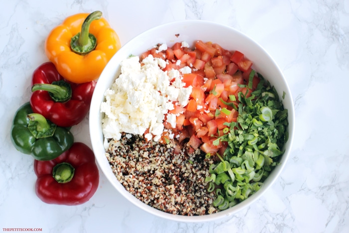 cooked quinoa, feta cheese, chopped tomatoes, chopped cilantro and chopped spring onion in  a large bowl