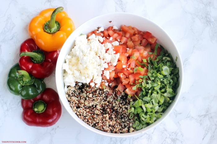 cooked quinoa, feta cheese, chopped tomatoes, chopped cilantro and chopped spring onion in a large bowl