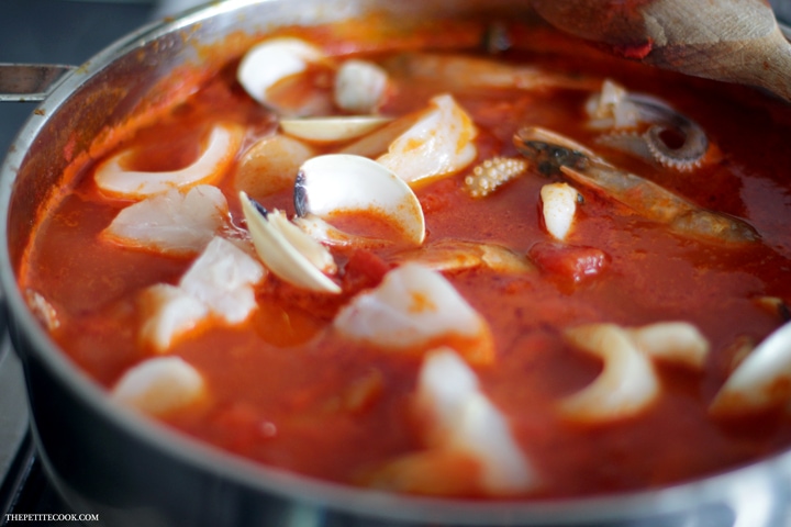 This simple Seafood Bouillabaisse is love at first spoon - Filled with aromatic Mediterranean flavors infused in a delicate saffron aroma, this light and easy version is ready in 30 mins and naturally gluten-free and dairy-free. Recipe from www.thepetitecook.com