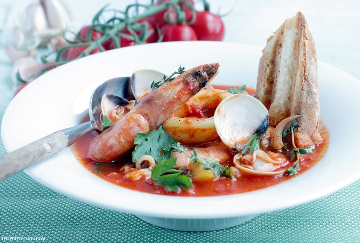 This simple Seafood Bouillabaisse is love at first spoon - Filled with aromatic Mediterranean flavors infused in a delicate saffron aroma, this light and easy version is ready in 30 mins and naturally gluten-free and dairy-free. Recipe from www.thepetitecook.com