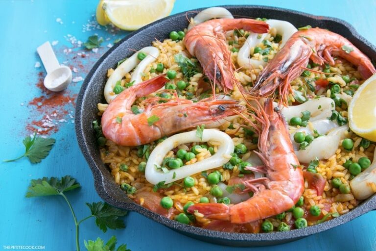 seafood apella topped with grilled shrimps calamari and lemon wedges