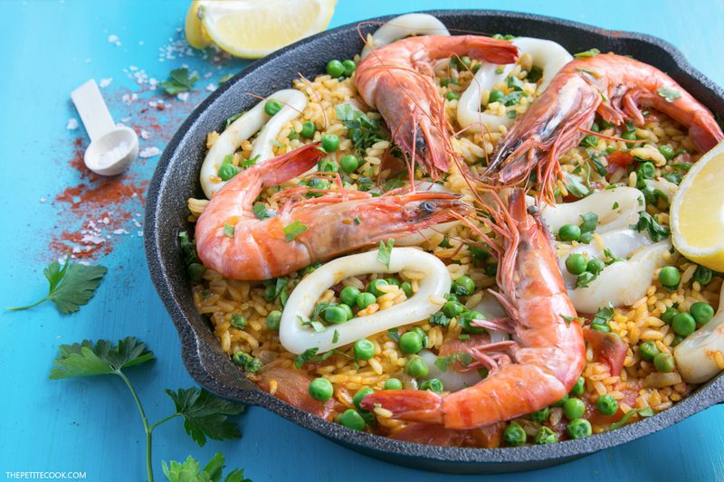 seafood apella topped with grilled shrimps calamari and lemon wedges