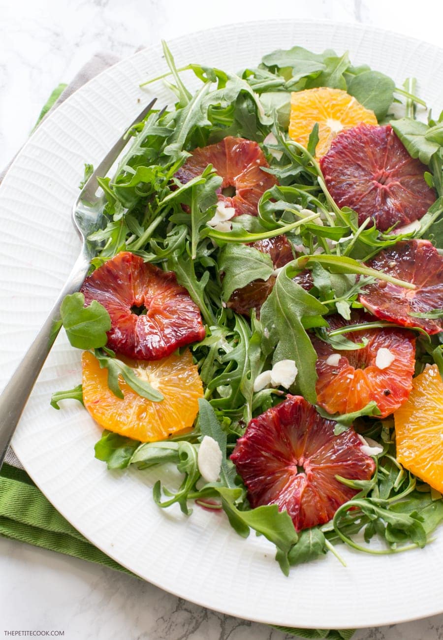 blood orange and rocket salad topped with almond flakes served on a plate
