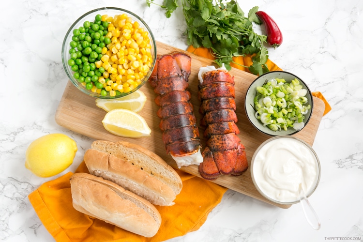 recipe ingredients: peas and sweetcorn in a bowl, 2 lobster tails, cilantrom red chili, spring onion, greek yogurt, hot dogs bun, lemon
