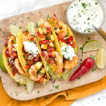 Give a vibrant refreshing twist on a Mexican favorite and try these Spicy Shrimp Tacos with Mango Salsa - The perfect Summer bite to share with friends! Recipe from www.thepetitecook.com