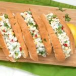 three summer lobster rolls on a wood board