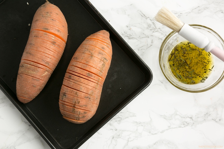 The easiest way to upgrade your typical baked potatoes. Crispy outside and fluffly melt-in-your mouth within, these Hasselback Sweet Potatoes with Guacamole make a great vegetarian spring or/and summer side! Recipe from www.thepetitecook.com