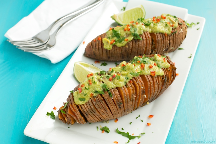 The easiest way to upgrade your typical baked potatoes. Crispy outside and fluffly melt-in-your mouth within, these Hasselback Sweet Potatoes with Guacamole make a great vegetarian spring or/and summer side! Recipe from www.thepetitecook.com