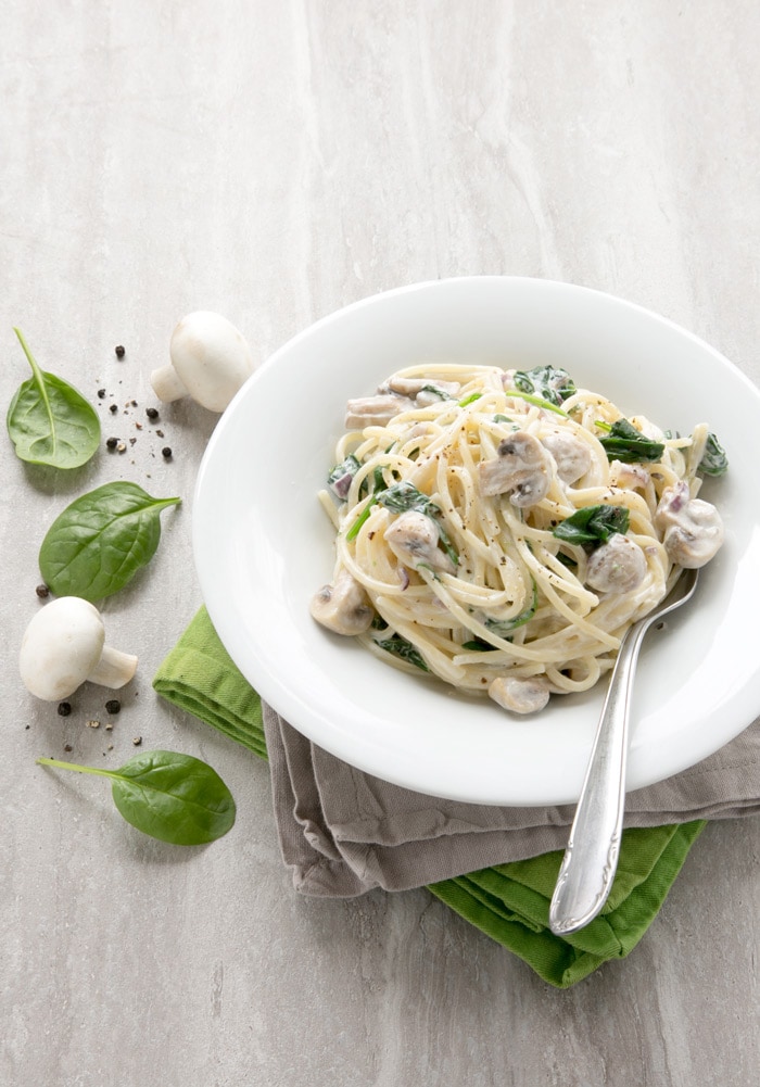 This Mushroom and Spinach Spaghetti recipe has the most amazing and easy creamy sauce - Vegetarian and packed with nutrients, it comes together in just 15 min! Recipe from www.thepetitecook.com