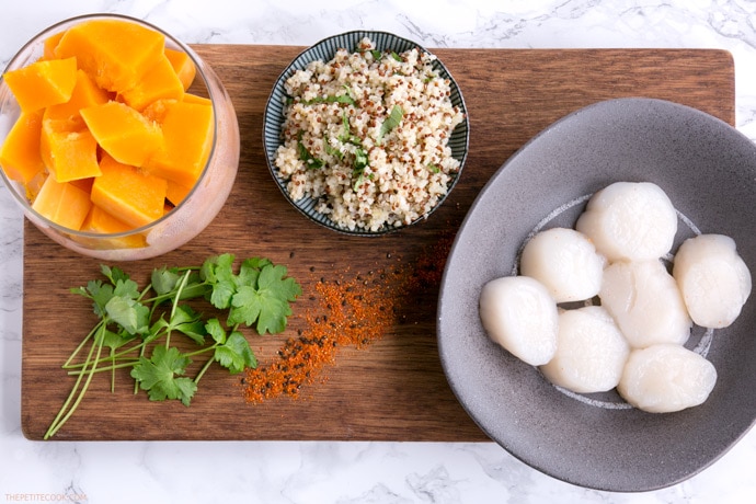 spicy scallops with pumpkin puree ingredients on a wood board