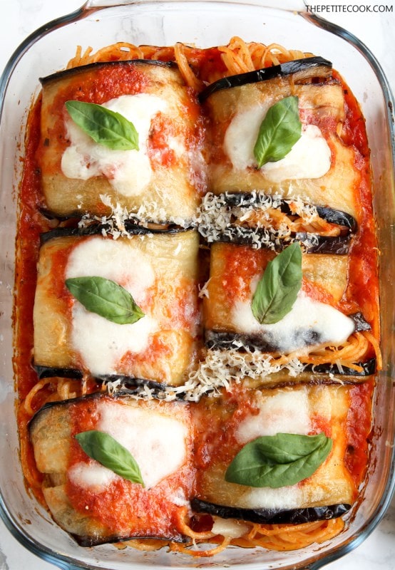 vegetarian eggplant spaghetti sandwiches topped with basil leaves in a glass baking dish