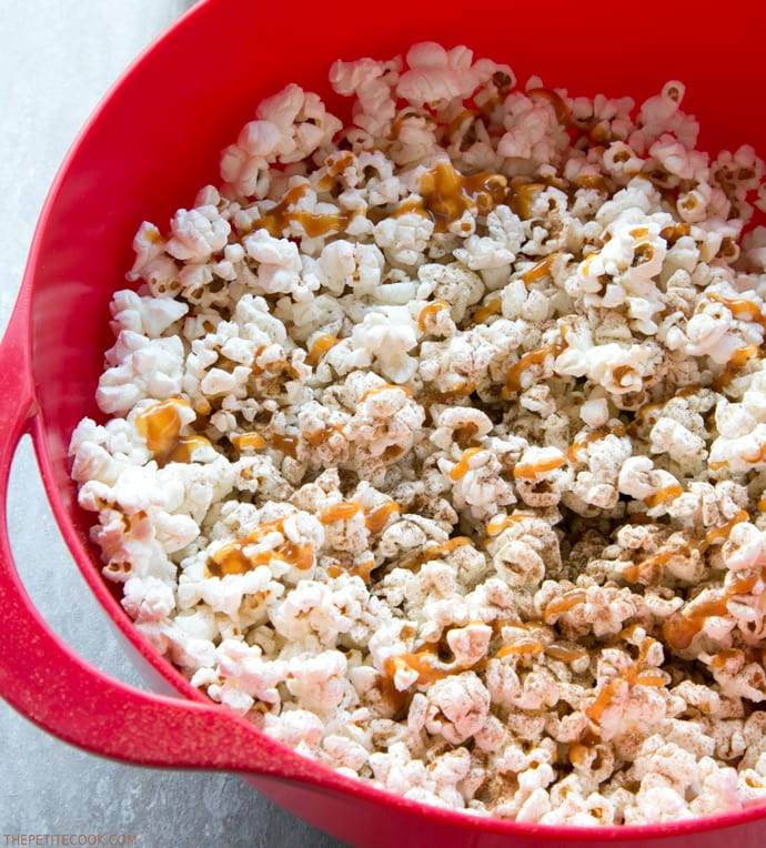 Salty, sweet, lightly spiced and crunchy, this super quick Caramel Pumpkin Spice Popcorn is sure to become your new favorite movie buddy! Recipe from www.thepetitecook.com