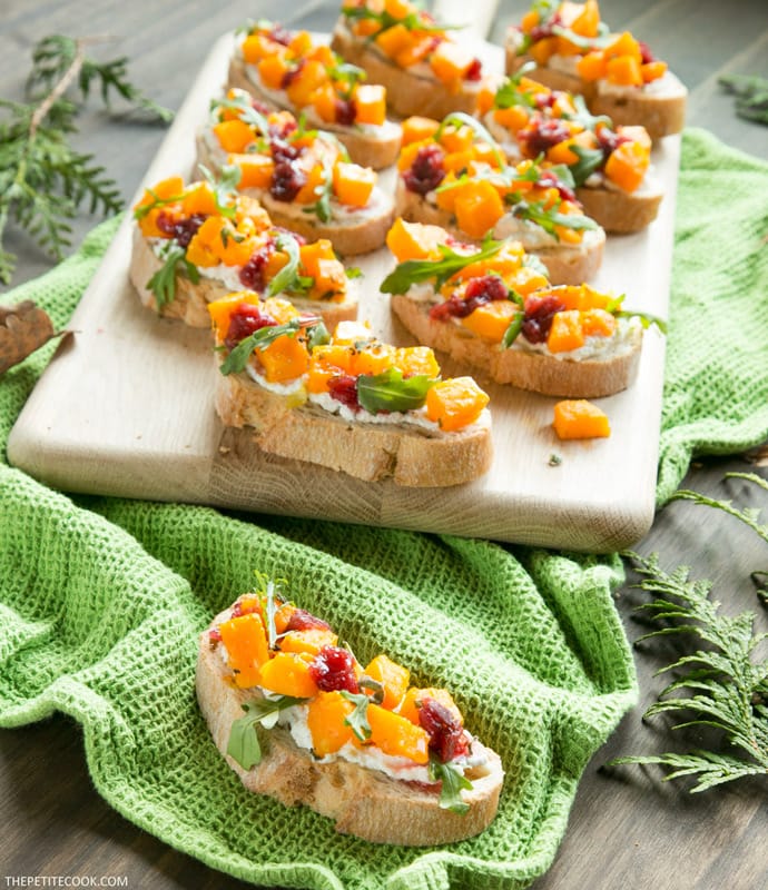 roasted pumpkin bruschetta on wood board and on green kitchen cloth