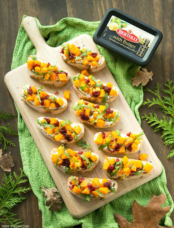 roasted pumpkin bruschetta on wood board and Bertolli spread packaging in the background