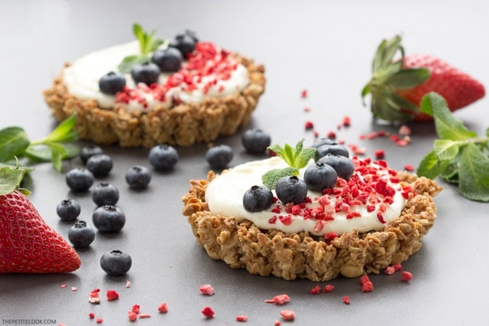 mascarpone granola tarts topped with blueberries and strawberry and mint.