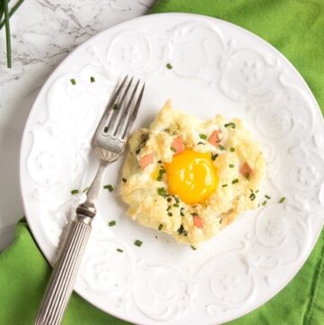 eggs in a cloud on a white plate with fork, over a green napkin