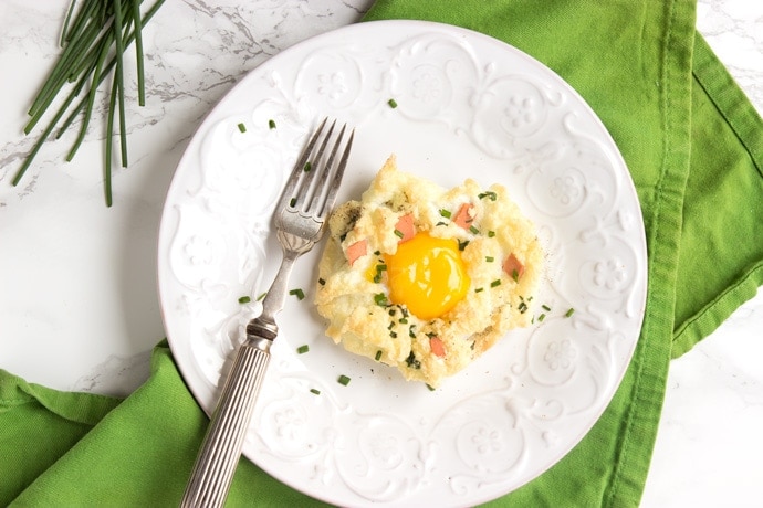 eggs in a cloud on a white plate with fork, over a green napkin