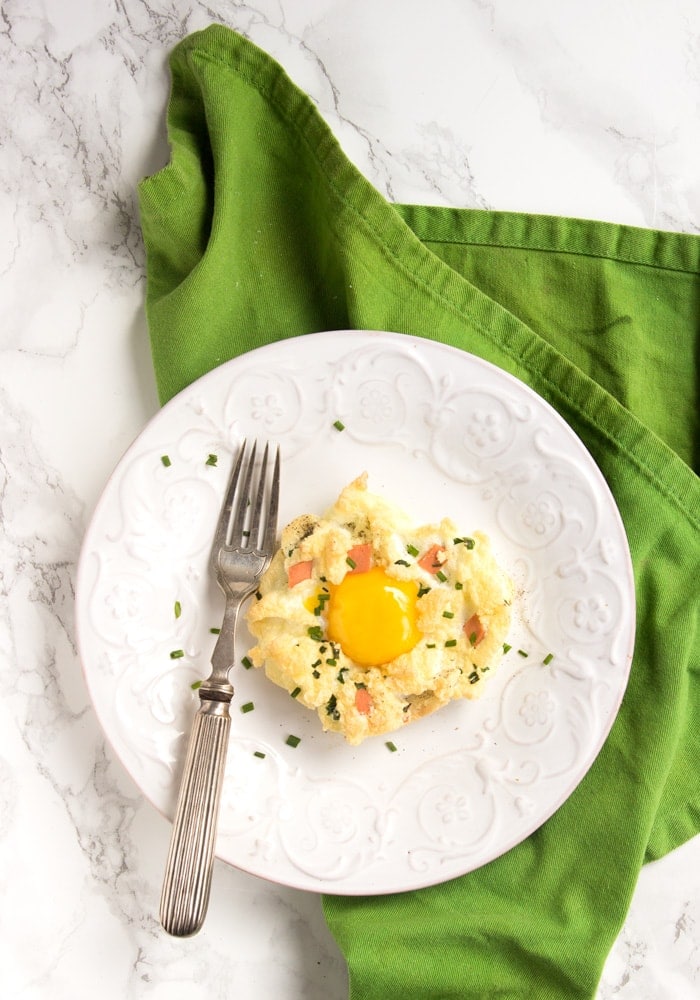 eggs in a cloud on a white plate with fork, over a green napkin