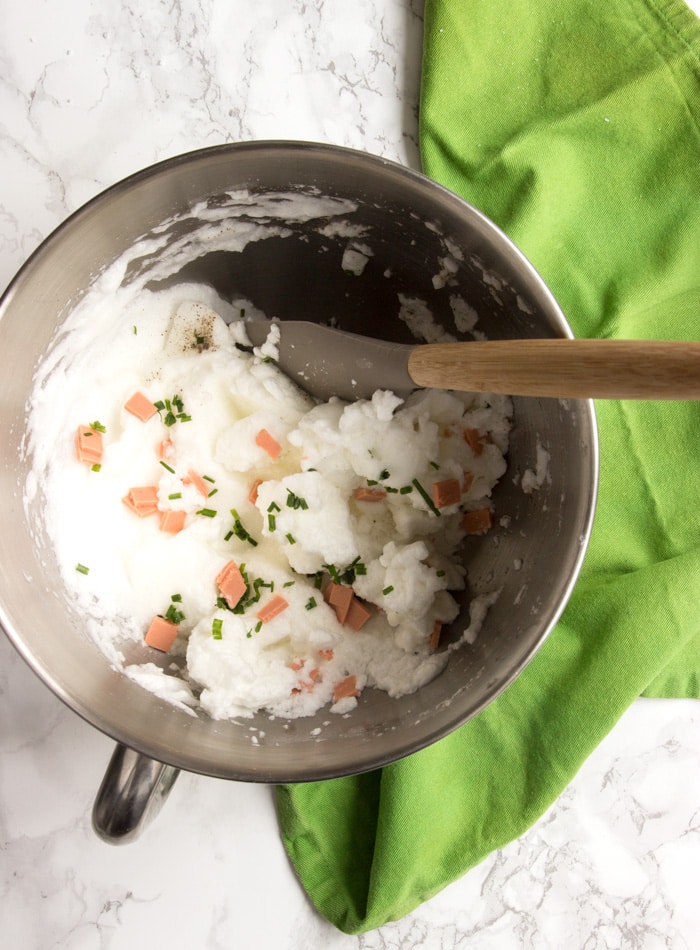 eggs in a cloud mixture in a bowl with a spatula, over a green napkin