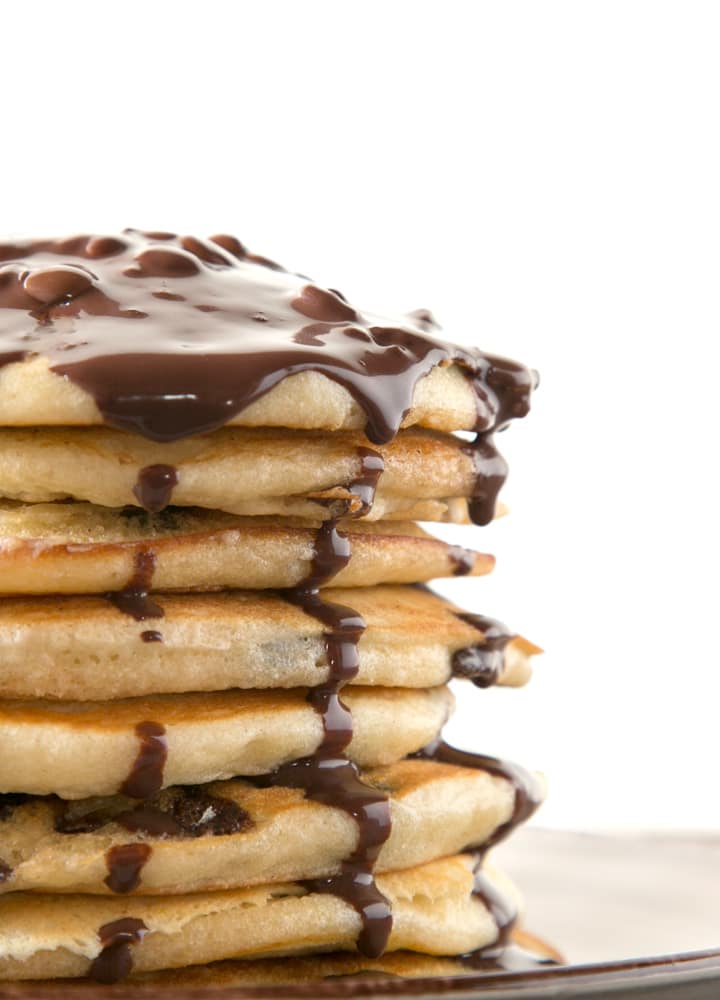 stack of american pancakes topped with chocolate sauce