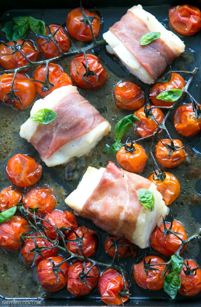 Make dinner time easy with this Prosciutto Wrapped Cod with Roasted Tomatoes - A one-tray easy italian-style meal, gluten-free, dairy-free and ready in just 20 min! Recipe by The Petite Cook - www.thepetitecook.com