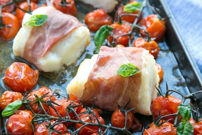 Make dinner time easy with this Prosciutto Wrapped Cod with Roasted Tomatoes - A one-tray easy italian-style meal, gluten-free, dairy-free and ready in just 20 min! Recipe by The Petite Cook - www.thepetitecook.com