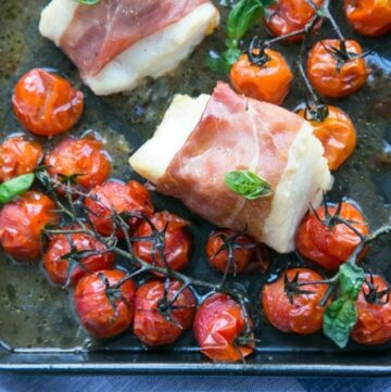 Make dinner time easy with this Prosciutto Wrapped Cod with Roasted Tomatoes - A one-tray easy italian-style meal, gluten-free, dairy-free and ready in just 20 min! Recipe by The Petite Cook - www.thepetitecook.com