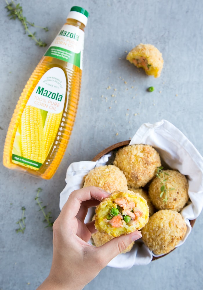 mazola oil bottle, hand holding a salmon and pea arancini