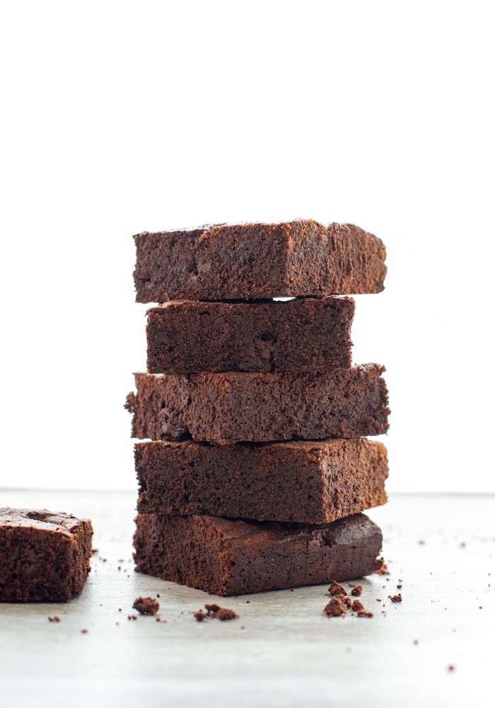 5 espresso brownies on top of each other, next to one other espresso brownies.